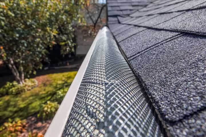 A contractor demonstrating the effectiveness of a gutter guard to a potential client in Douglasville